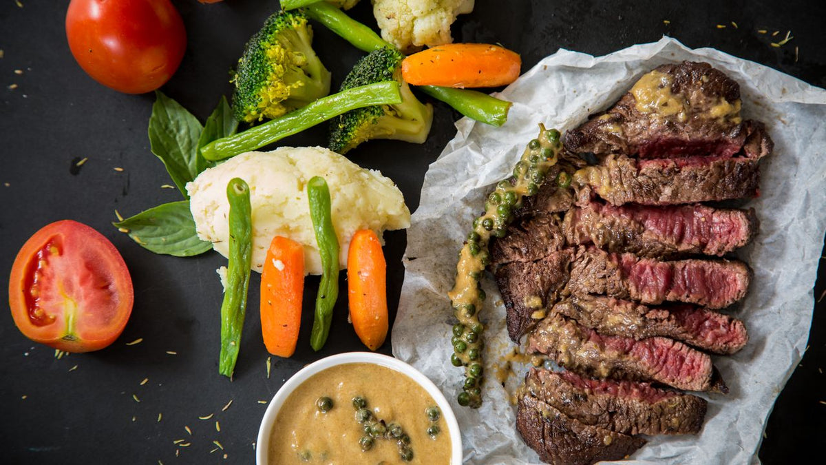 A plate of sliced steak with vegetables, an iron-rich meal